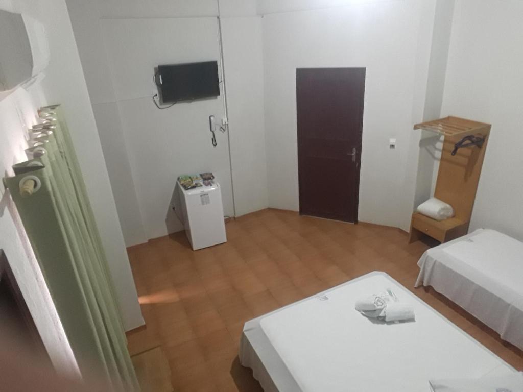 吉巴拉那Hotel Chalé Ji-Parana的白色的小房间,配有床和桌子
