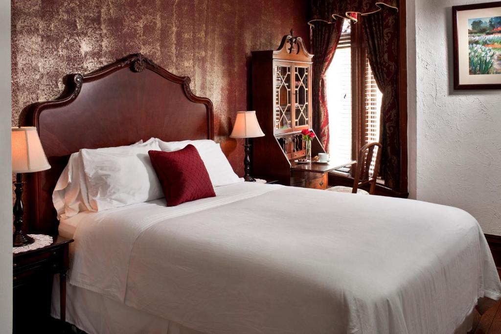 华盛顿美国宾馆的卧室配有带红色枕头的大型白色床