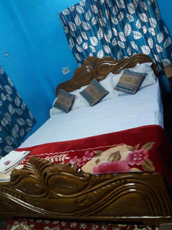 加尔各答Kiran Guest House的一张木制床,上面有枕头
