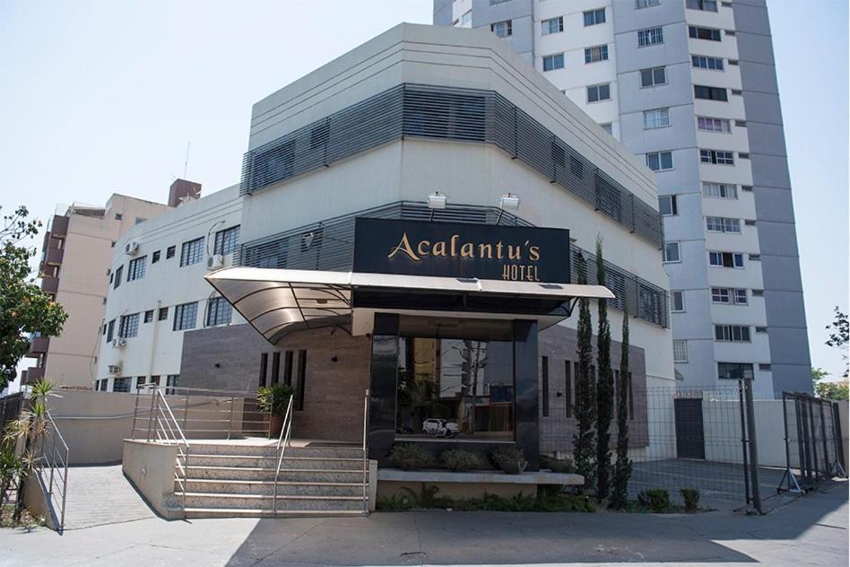 戈亚尼亚Acalantus Hotel的公寓大楼前方有标志