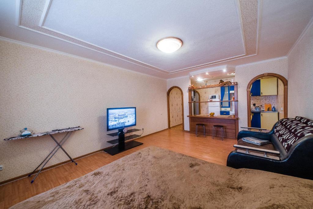 托木斯克Большая Подгорная 57 квартира-студия с утепленной лоджией的客厅配有沙发和墙上的电视