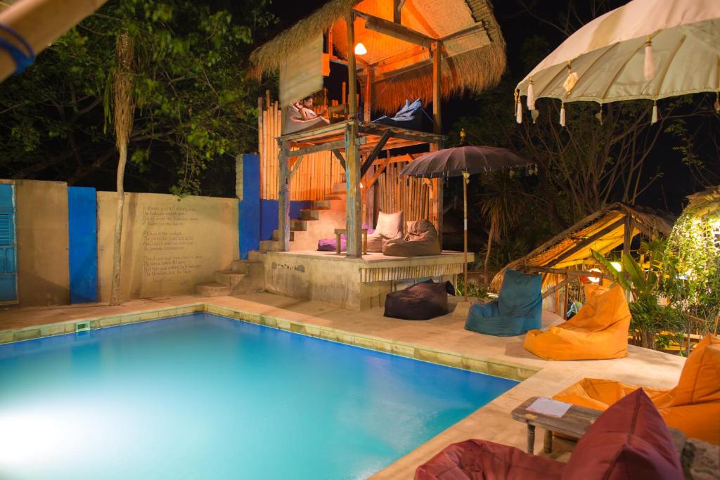 吉利特拉旺安吉利拉波希米亚旅馆的一座带遮阳伞的房屋前的游泳池