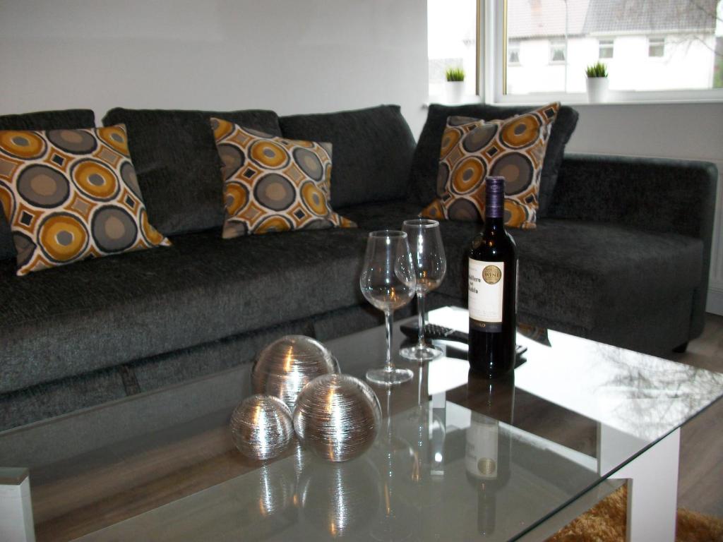 东基尔布赖德Westpark Apartment的客厅配有沙发和带酒杯的桌子