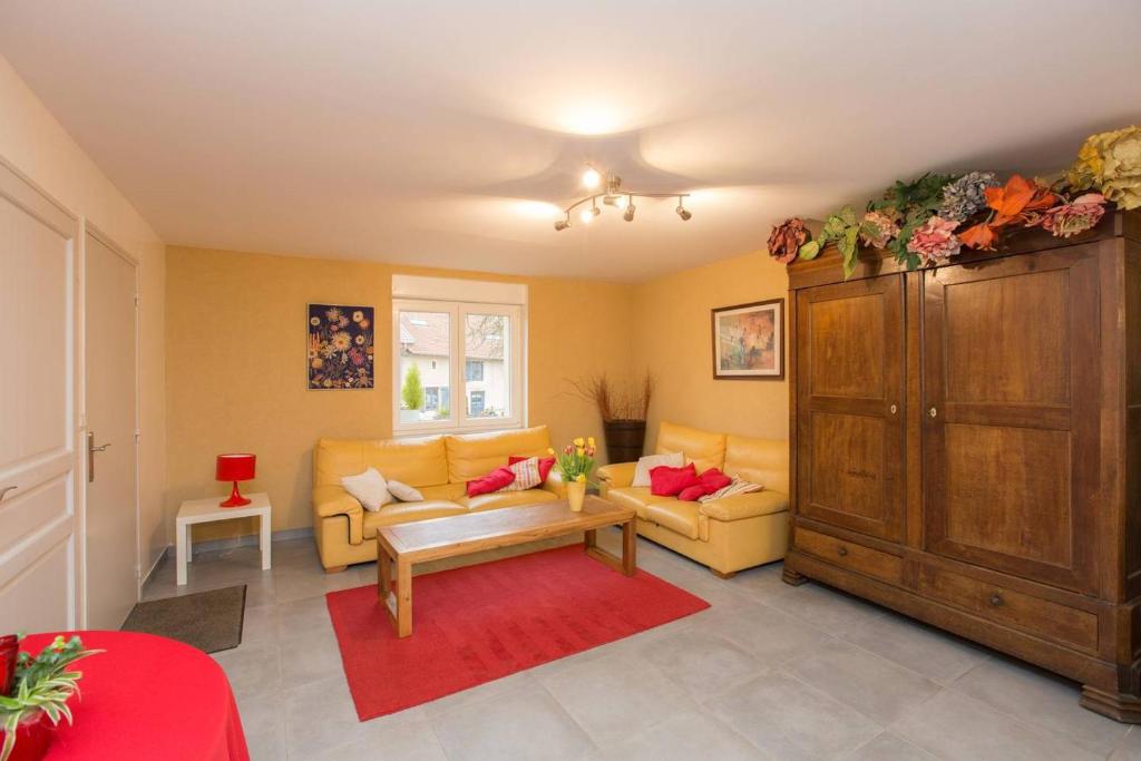 MarieullesLes Coquelicots的客厅配有黄色家具和红色地毯。
