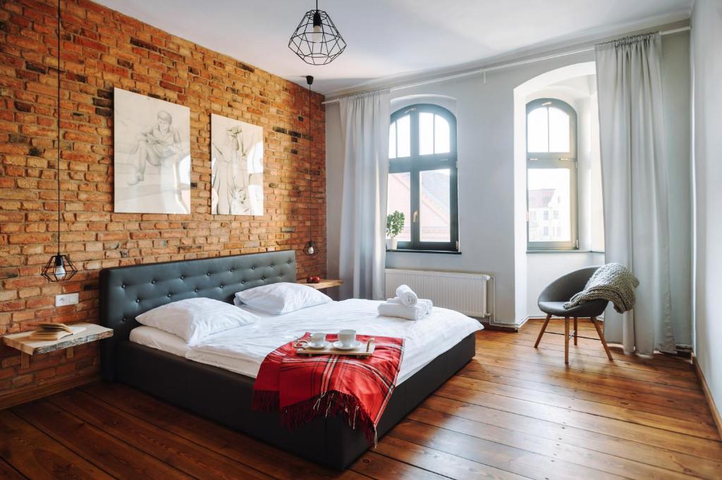 托伦欧罗巴公寓的一间卧室设有一张带砖墙的大床