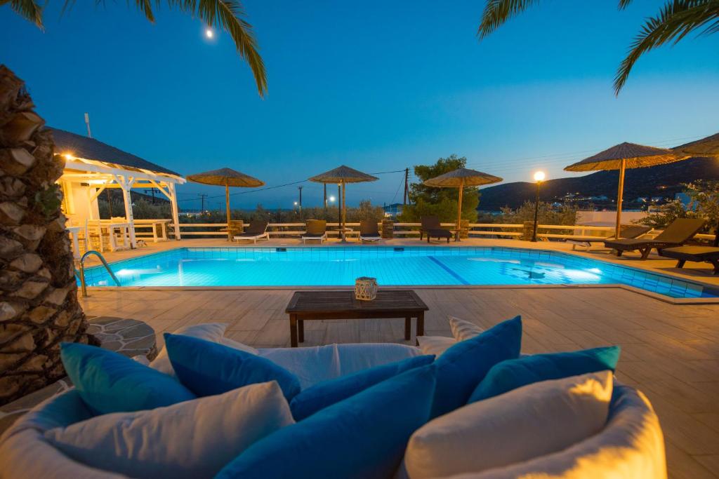 普拉提伊亚洛斯西弗诺斯伊里尼公寓式酒店的一个带沙发和桌子的游泳池以及一个游泳池