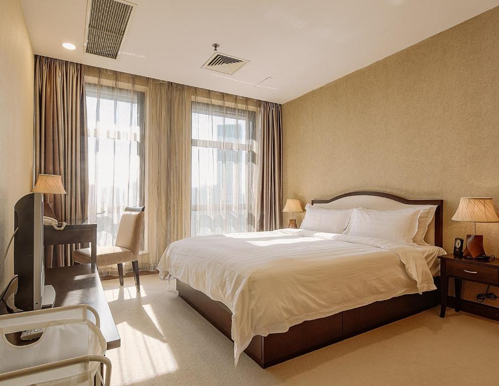 大连大连雅泰服务公寓（原盛捷港湾服务公寓）的一间卧室设有一张大床和一个窗户。