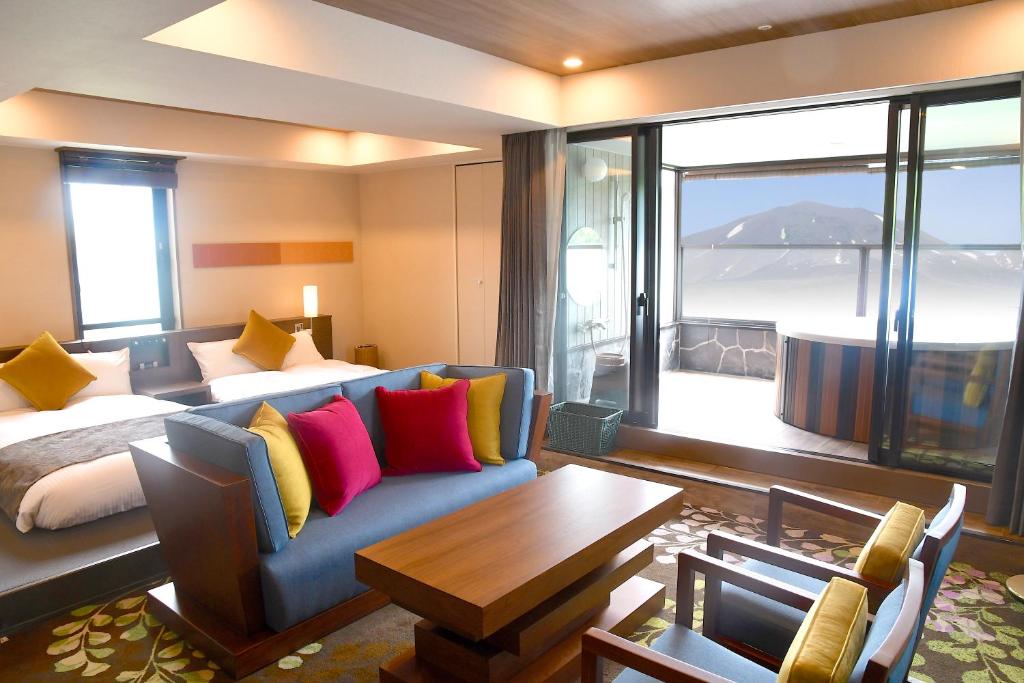 嬬恋村Karuizawakurabu Hotel 1130 Hewitt Resort的酒店客房配有床、沙发和桌子。