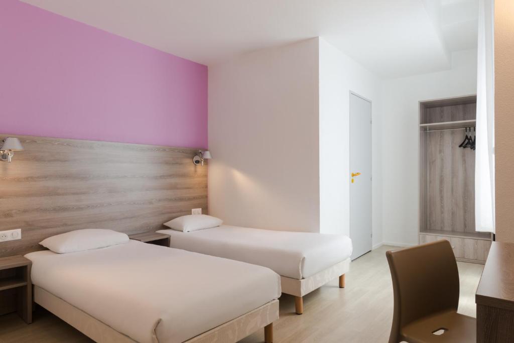 讷韦尔The Originals City, Hôtel Nevers Centre Gare (Inter-Hotel)的紫色和白色墙壁客房的两张床