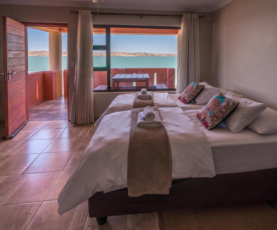 吕德里茨Island Cottage Guesthouse的一间卧室设有一张大床,享有海景