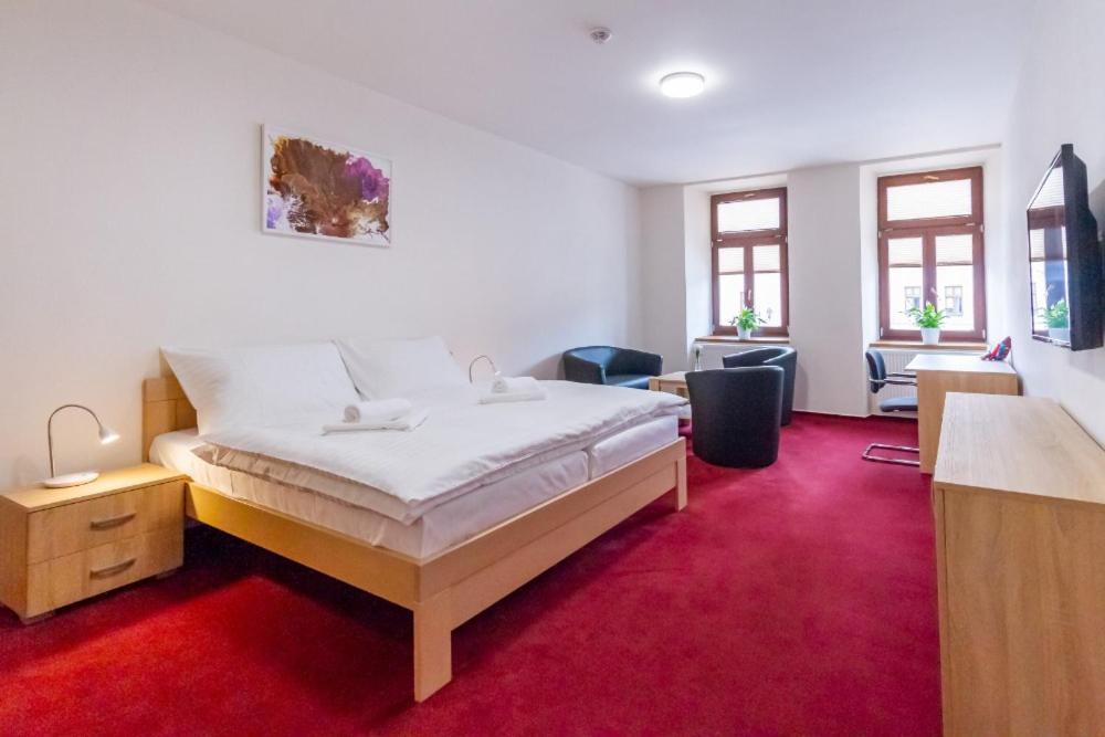 斯维塔维Hotel Ungar的一间卧室配有一张床,铺有红色地毯