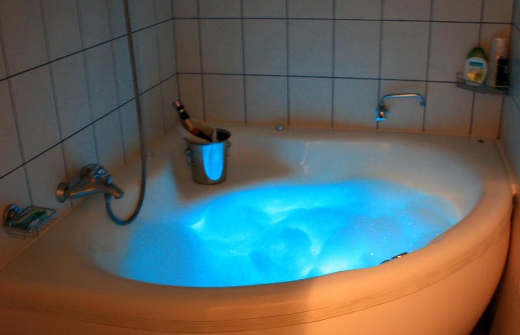 里加萨姆皮特拉玛雅宾馆的浴室设有蓝色水浴缸