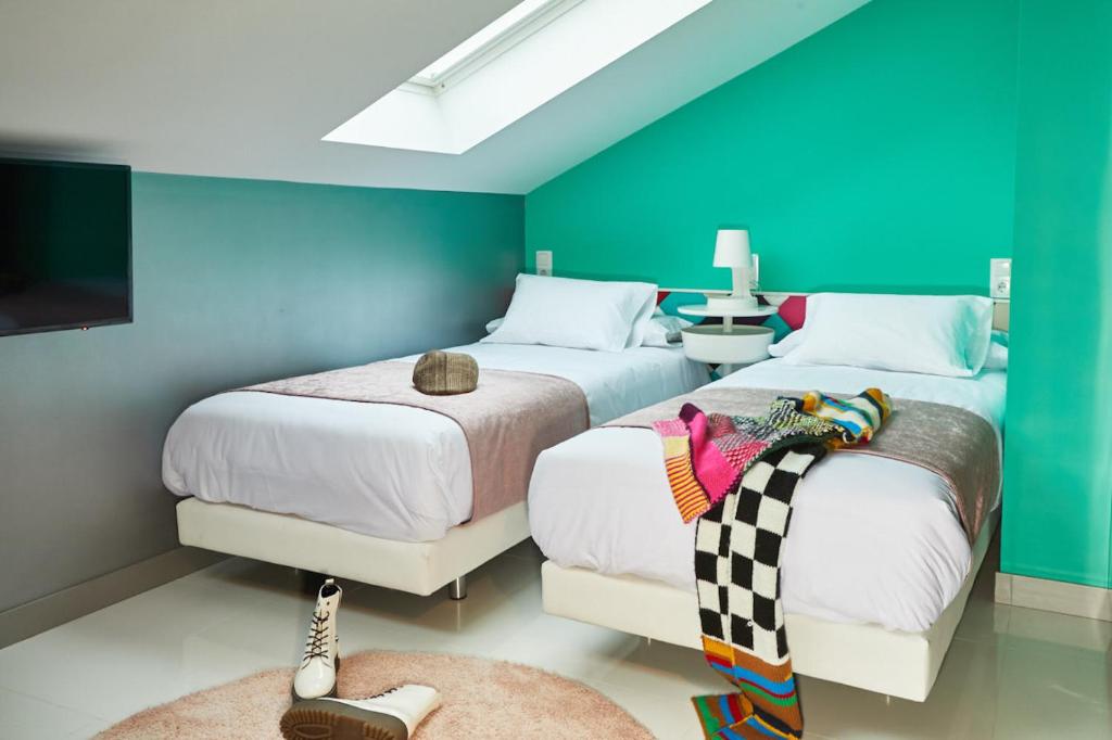 马德里Hotel Freedom的配有两张床铺的蓝色和绿色墙壁客房