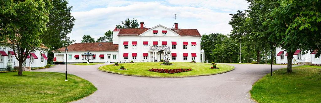 DejeDömle Herrgård Spa & Resort的一座白色的大房子,前面设有一个花园