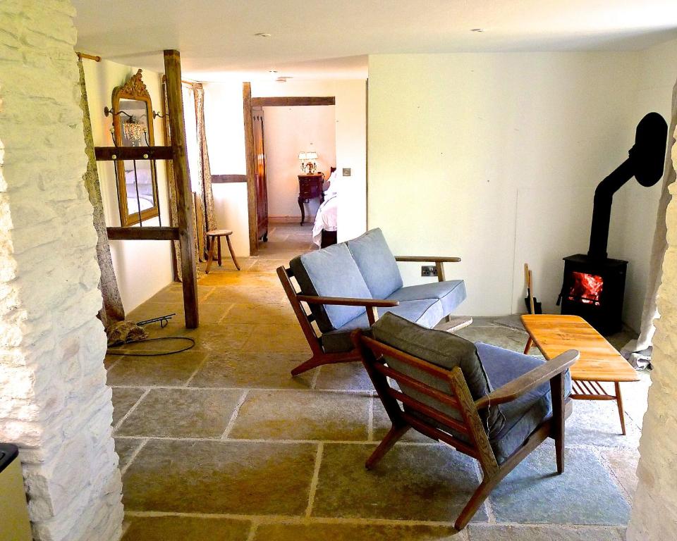 瓦伊河畔海伊Glanwye的客厅配有两把椅子和壁炉