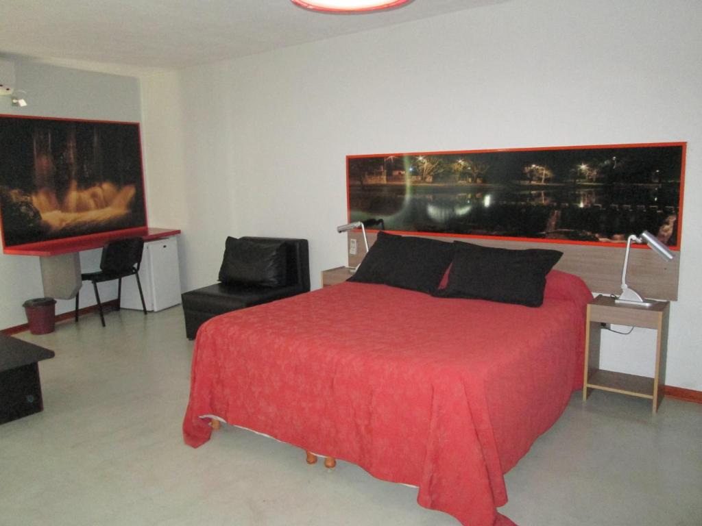 米娜克拉韦罗城市套房住宿加早餐旅馆的一间卧室配有红色的床和椅子