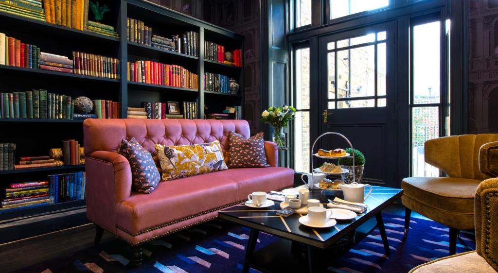 伦敦The Academy - Small Luxury Hotels of the World的客厅配有粉红色的沙发和桌子