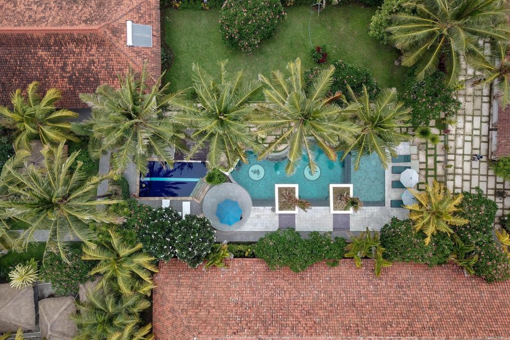 龙目岛库塔Segara Anak Hotel的享有带游泳池和棕榈树的度假村的顶部景致