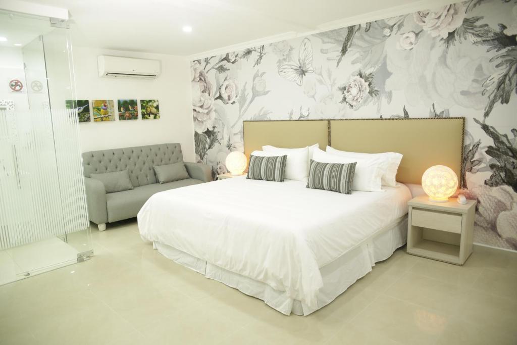 阿帕尔塔多HOTEL HABANA REAL的卧室配有一张白色的大床和一张沙发。