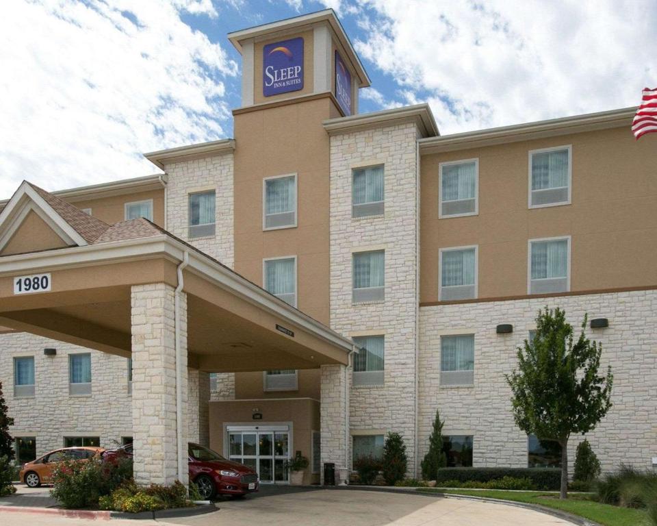 圆石城Sleep Inn and Suites Round Rock - Austin North酒店的一座酒店大楼,上面有一个钟楼