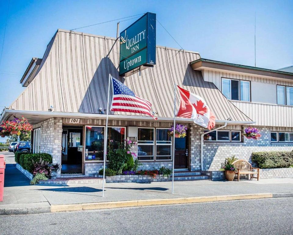 安吉利斯港Quality Inn Port Angeles - near Olympic National Park的前面有两面美国国旗的餐厅