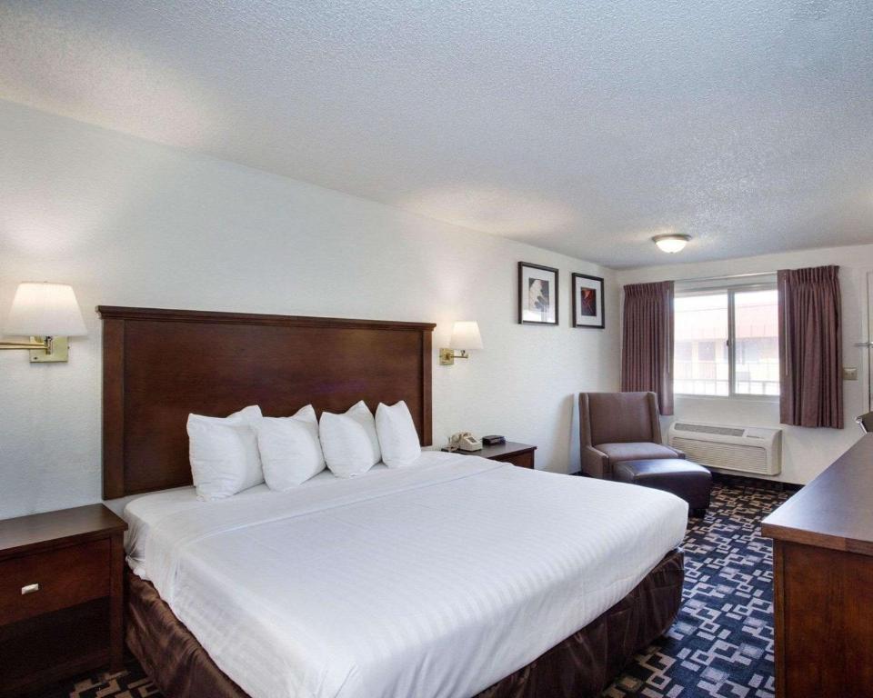 贝灵厄姆MorningGlory Inn & Suites的酒店客房带一张大床和一把椅子