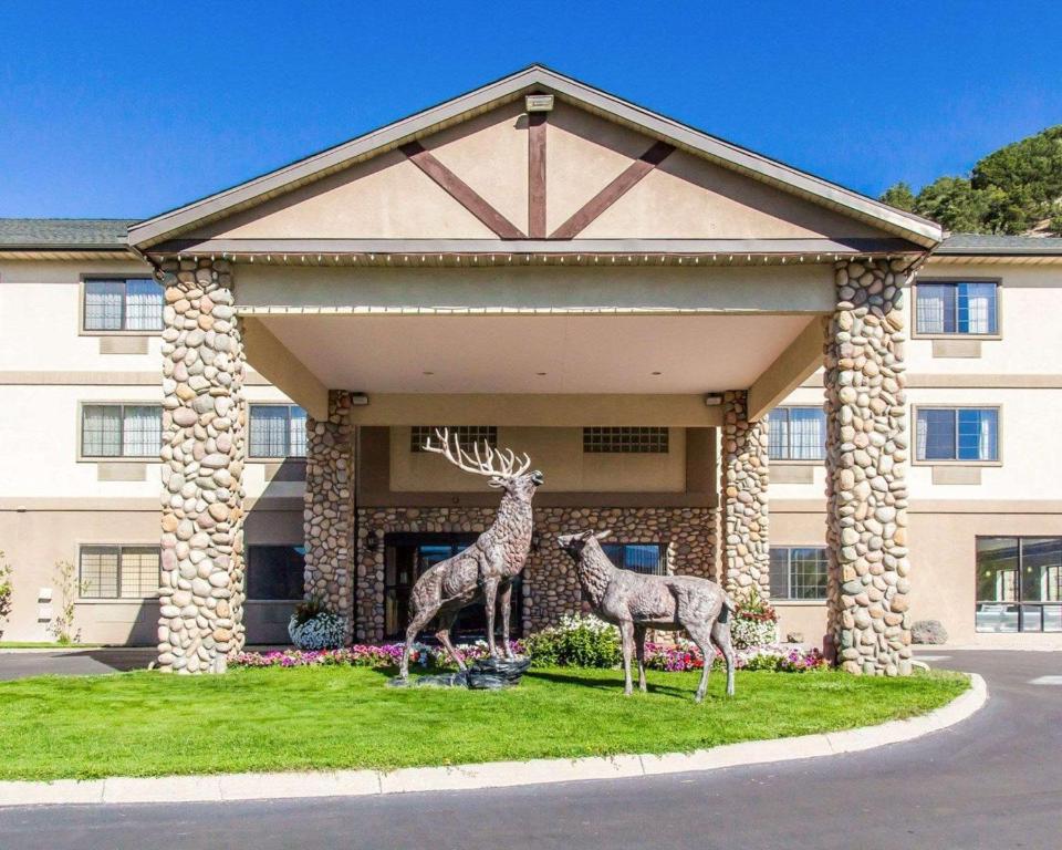 伊格尔Quality Inn & Suites Vail Valley的建筑前两长颈鹿雕像