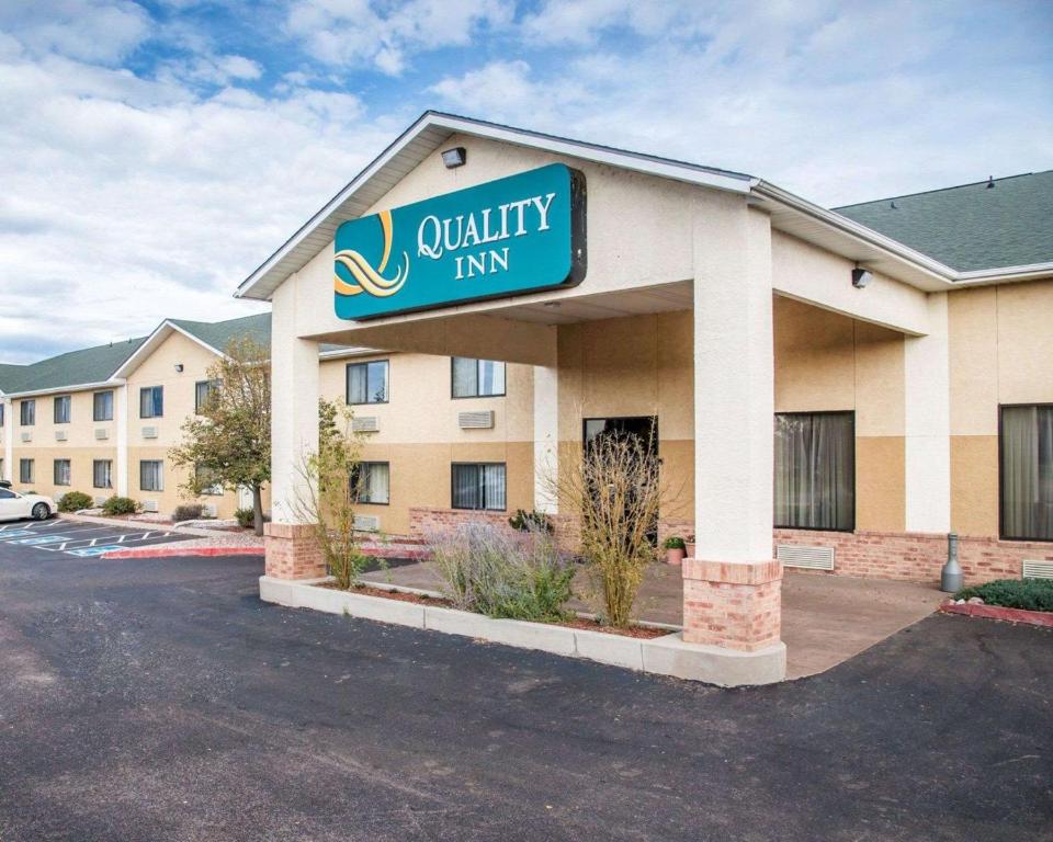 科罗拉多斯普林斯Quality Inn Airport的建筑前方的优质旅馆标志