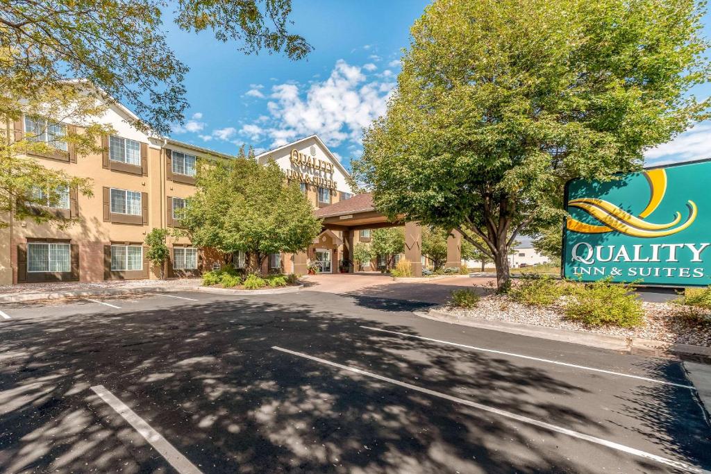 柯林斯堡Quality Inn & Suites University Fort Collins的一座建筑,上面标有优质旅馆和套房的标志