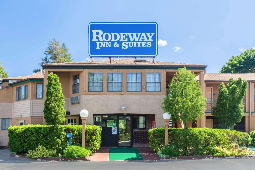 布兰福德Rodeway Inn & Suites Branford - Guilford的罗德威旅馆和套房标志在大楼的顶部