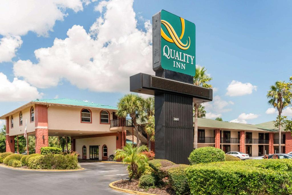 奥兰多Quality Inn & Suites Orlando Airport的建筑前的优质旅馆标志