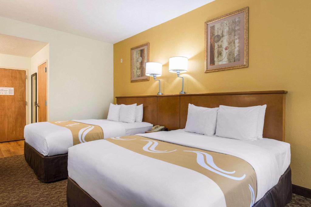 奥兰多Quality Inn & Suites Near the Theme Parks的酒店客房设有两张床和两盏灯。