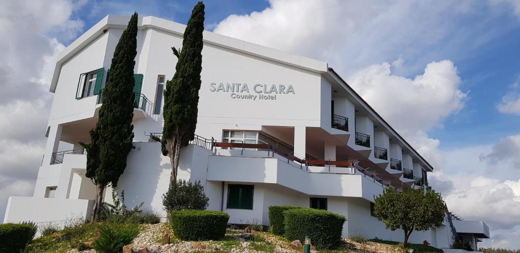 旧圣克拉拉Santa Clara Country Hotel的白色的建筑,上面标有读取santa clara联排别墅的标志