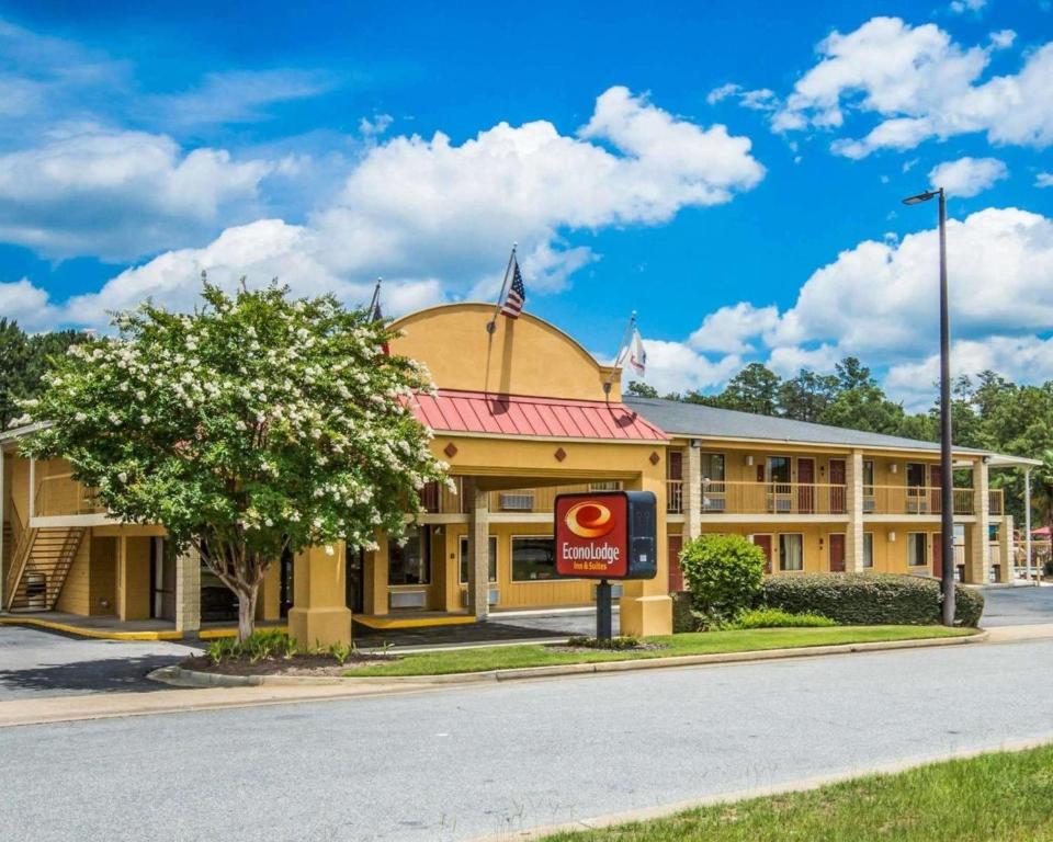 哥伦布Econo Lodge Inn & Suites at Fort Moore的黄色的建筑,前面有标志