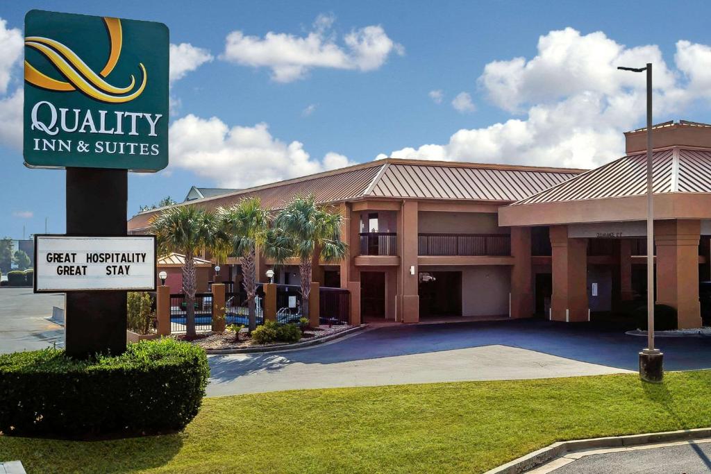 华纳罗宾斯Quality Inn & Suites near Robins Air Force Base的建筑前的优质旅馆和套房标志