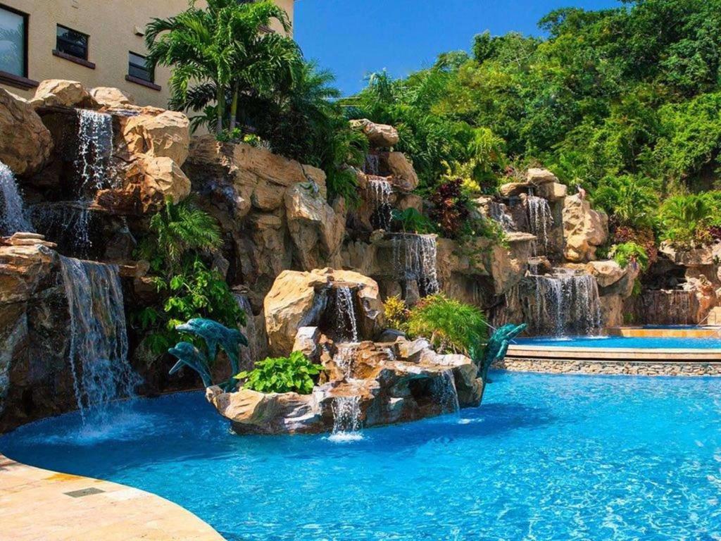 First Bight罗丹菠萝别墅号角套房酒店的度假村内带瀑布的游泳池