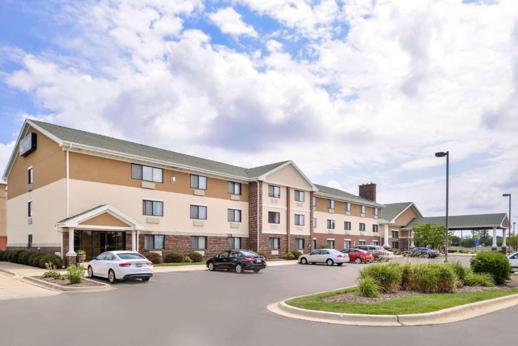 波林布鲁克Quality Inn Bolingbrook I-55的停车场内有车辆的建筑物