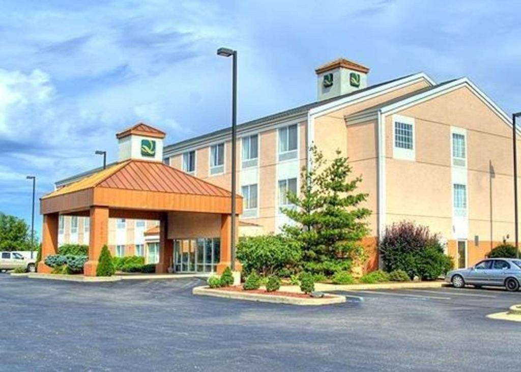 卡拉马祖Quality Inn I-94 near Wings Stadium的停车场内有停车位的大型建筑