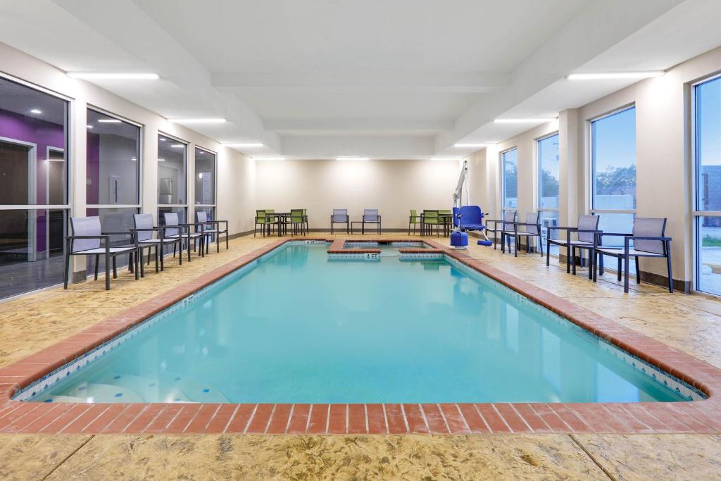 科珀斯克里斯蒂Wingate by Wyndham Corpus Christi的大楼内带桌椅的大型游泳池