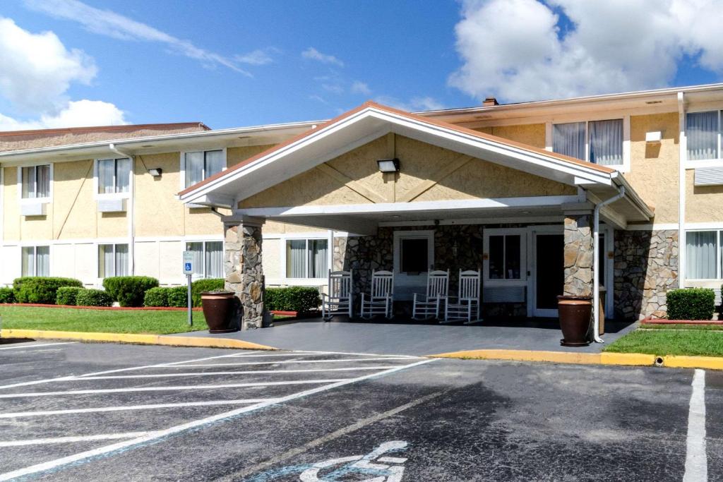 杰克逊维尔Rodeway Inn & Suites Jacksonville near Camp Lejeune的前面有停车位的大楼