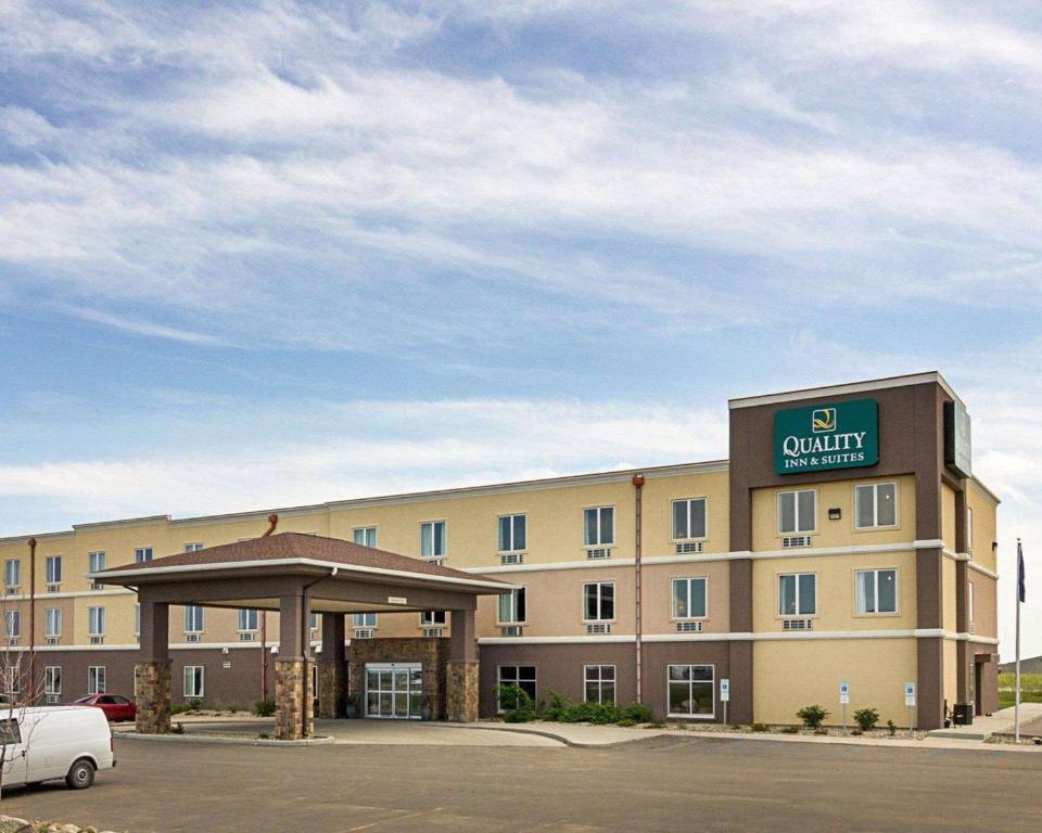 迈诺特Quality Inn & Suites的停车场内有停车位的酒店大楼