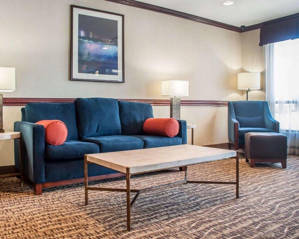 奇克托瓦加Quality Inn Near Walden Galleria Mall的客厅配有蓝色的沙发和两把椅子