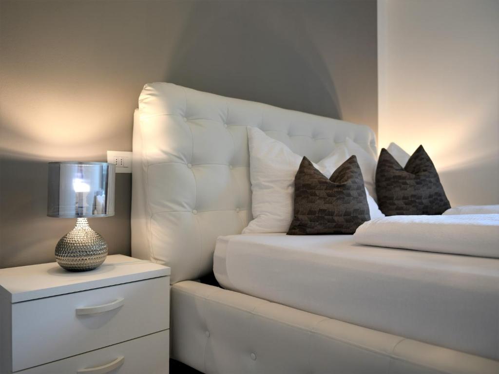 塞尔瓦迪加尔代纳山谷Appartamento Dolomiti的一间卧室配有一张带白色床头板和枕头的床。