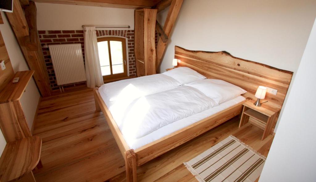 Neuburg-SteinhausenGästehaus Landgut Lischow的一间卧室配有一张大床和木制床头板
