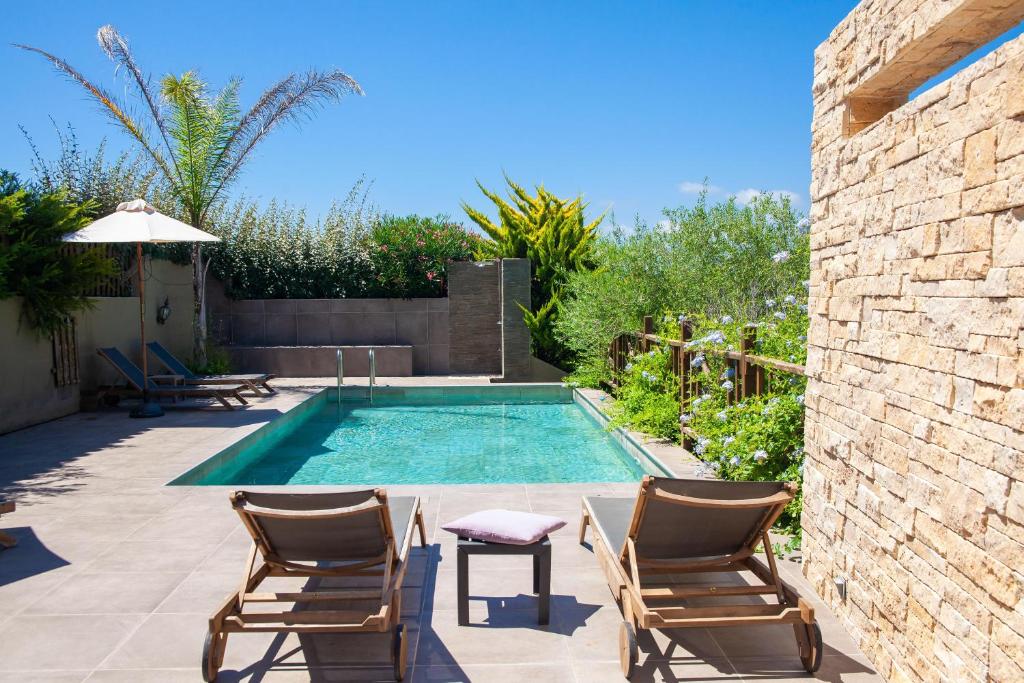 普罗普里亚诺胡德尔莫尼住宿酒店的庭院内的游泳池,配有两把椅子和一张桌子