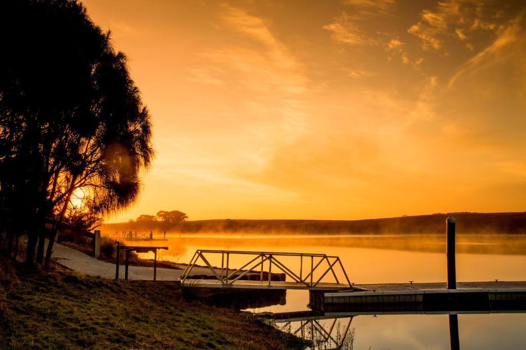 沃纳姆堡NRMA Warrnambool Riverside Holiday Park的湖面上的日落,木船坞
