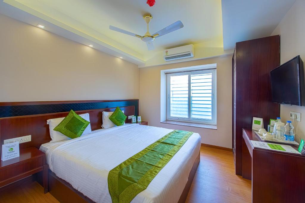 加尔各答Treebo Trend Vedanta的一间卧室设有一张大床和一个窗户。