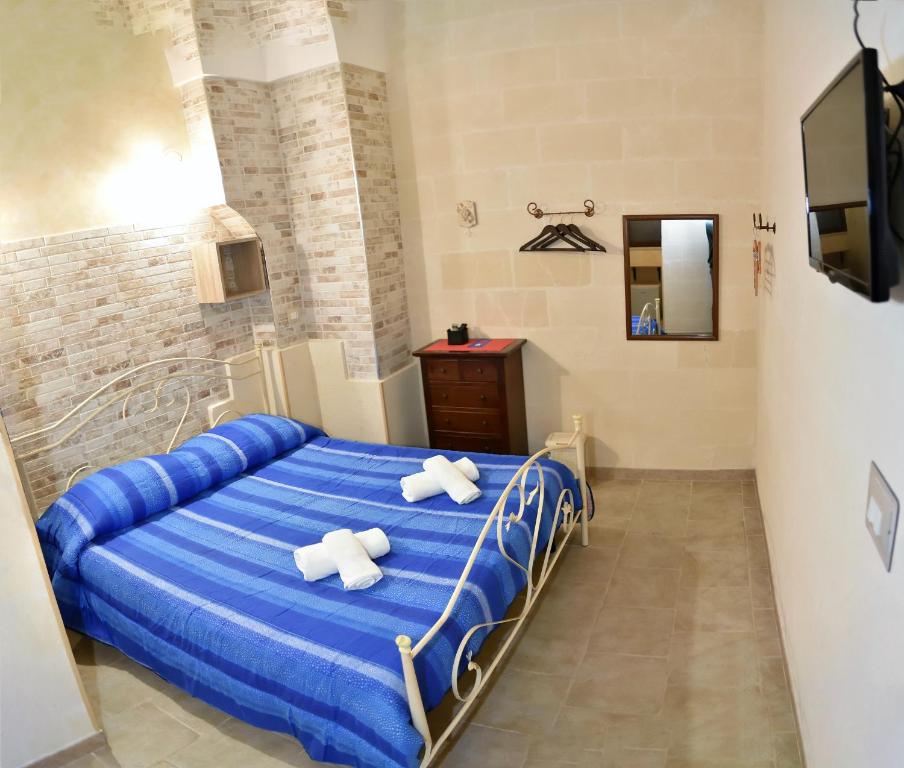 阿韦特拉纳Cala del Conte b&b的一间卧室配有蓝色的床和2条白色毛巾