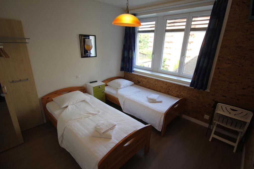 沃韦Hotel Abaca的小型客房 - 带2张床和窗户