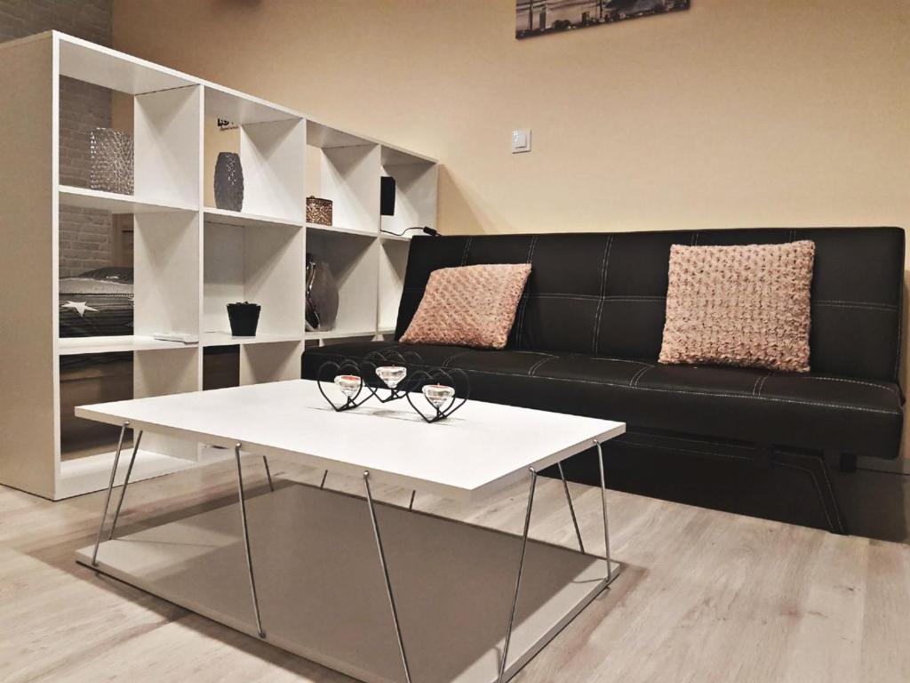 阿特米达AURORA的客厅配有黑色沙发和白色桌子